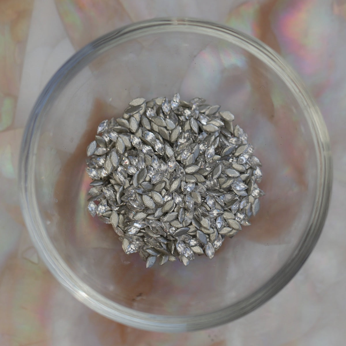 Pile of clear zircon marquise crystals in flatback form, illustrating premium pointed oval rhinestones for professional nail artists and creative projects
