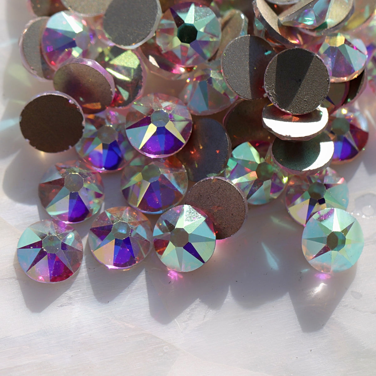 Flatback Crystal AB rhinestones with a 16-facet (8+8) cut and metallic foil backs scattered in a shimmering pile.