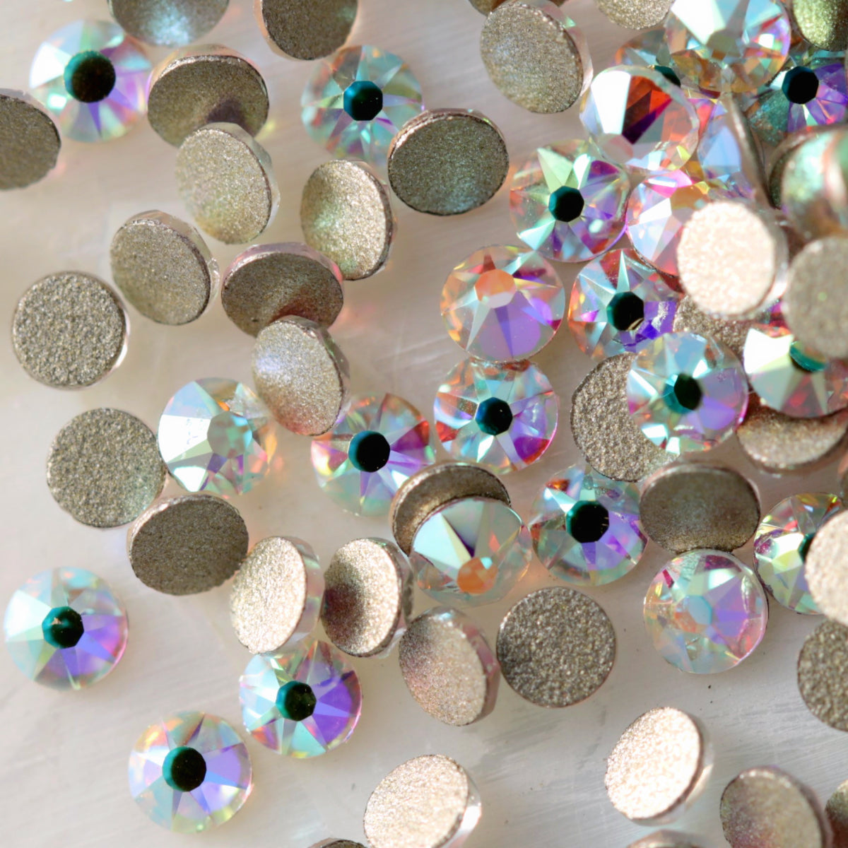 Flatback Crystal AB rhinestones with a 16-facet (8+8) cut and metallic foil backs scattered in a shimmering pile.