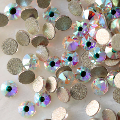 Flatback Crystal AB rhinestones with a 16-facet (8+8) cut and metallic foil backs scattered in a shimmering pile.