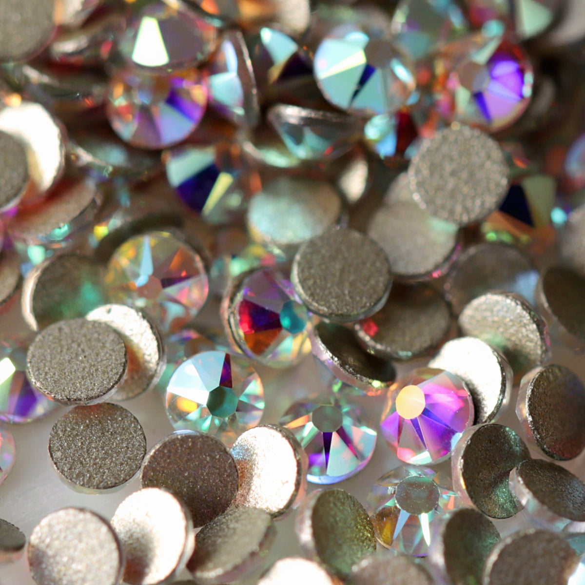 Flatback Crystal AB rhinestones with a 16-facet (8+8) cut and metallic foil backs scattered in a shimmering pile.