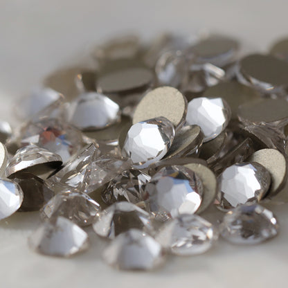 Clear flatback rhinestones with a 16-facet (8+8) cut and metallic foil backs forming a sparkling pile.