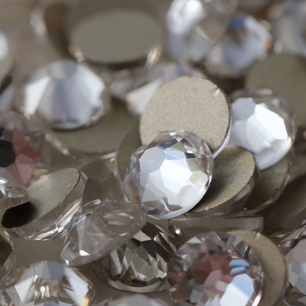 Clear flatback rhinestones with a 16-facet (8+8) cut and metallic foil backs forming a sparkling pile.