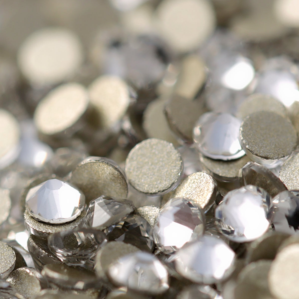 Clear flatback rhinestones with a 16-facet (8+8) cut and metallic foil backs forming a sparkling pile.