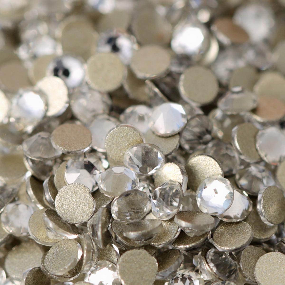 Clear flatback rhinestones with a 16-facet (8+8) cut and metallic foil backs forming a sparkling pile.