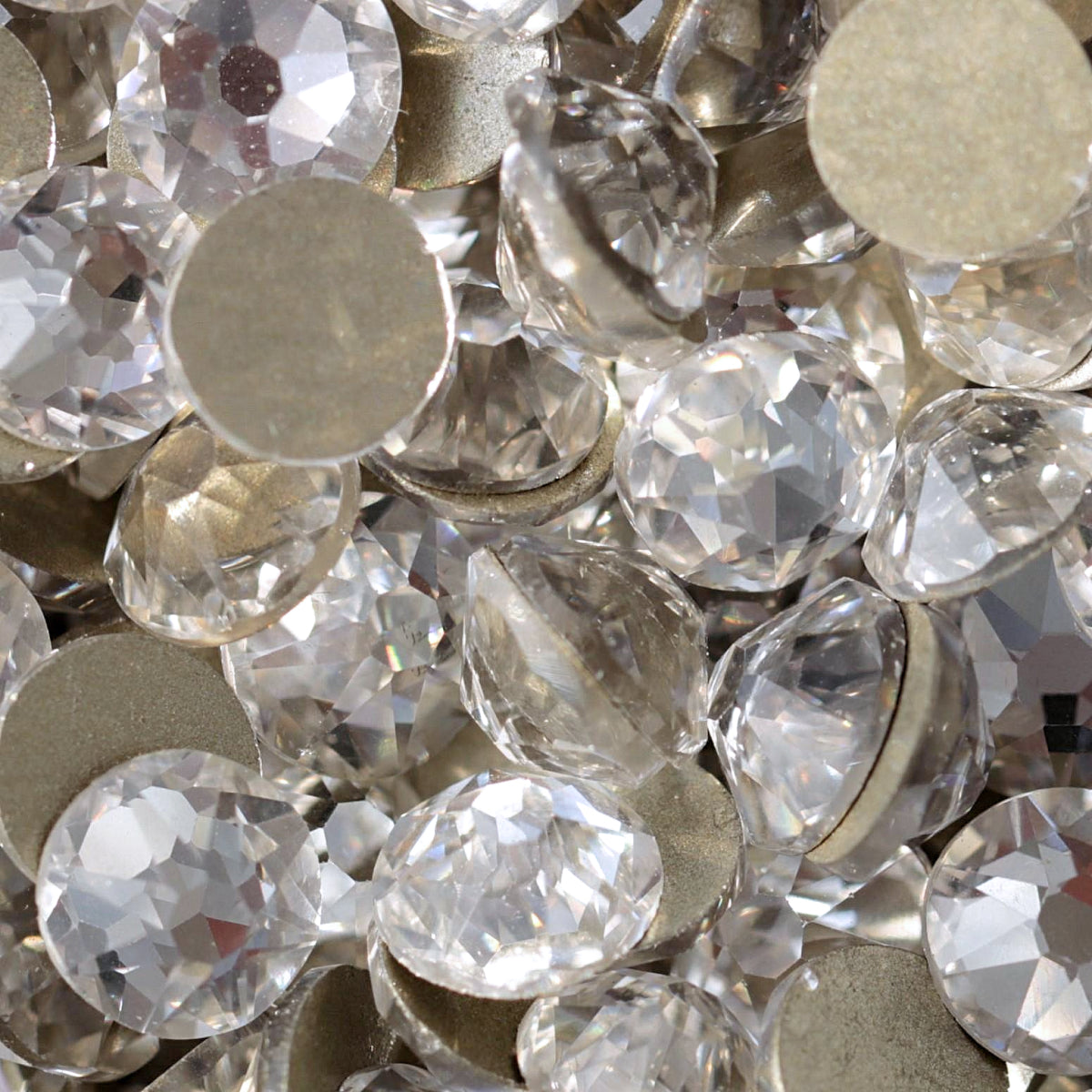 Clear flatback rhinestones with a 16-facet (8+8) cut and metallic foil backs forming a sparkling pile.
