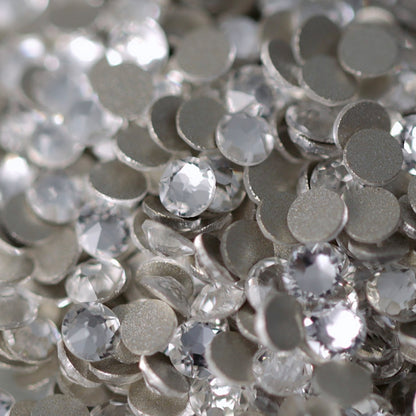 Clear Flatback K9 Crystal rhinestones with faceted tops and metallic foil backs scattered in a sparkling pile.