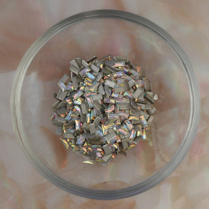 Iridescent Crystal AB flatback zircon baguette crystals in 3x1.5mm size scattered on a light background, showing elongated rectangular stones for nail art and decorations.