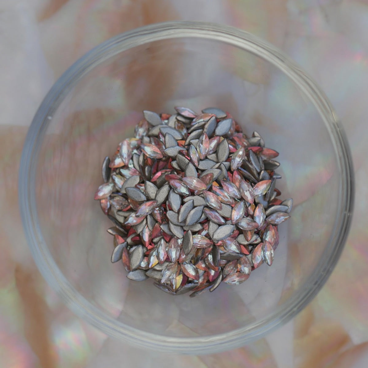 Flatback Zircon Nail Art Marquise Copper AB crystals scattered on a surface, showing warm copper iridescent navette stones with silver flatbacks for nail art and decorations.