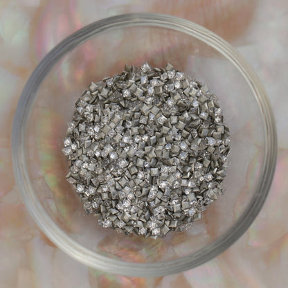 Bowl filled with clear zircon flatback square crystals, illustrating premium miniature square rhinestones for professional nail artists and detailed decorations