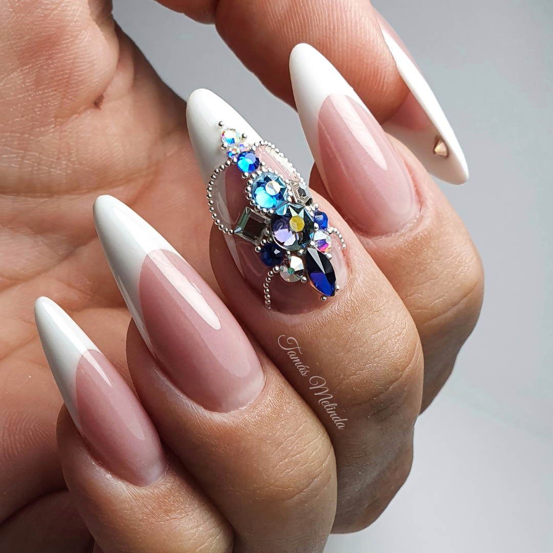 Elegant nude and white French manicure with a central blue and clear crystal cluster, inspiring creative nail designs using Eunails flatback rhinestones and beads