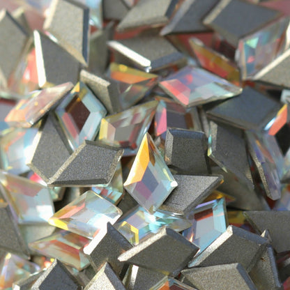 Pile of faceted K9 crystal deltoid flatbacks Crystal Gold Shimmer showing rainbow refractions gold shimmer and silver foil base on light pink surface