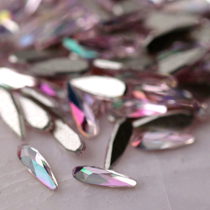 Close-up of K9 Crystal Flatback Raindrop Luminous Light Rose crystals, highlighting the delicate pink color and high-shine raindrop shape ideal for elegant manicures.