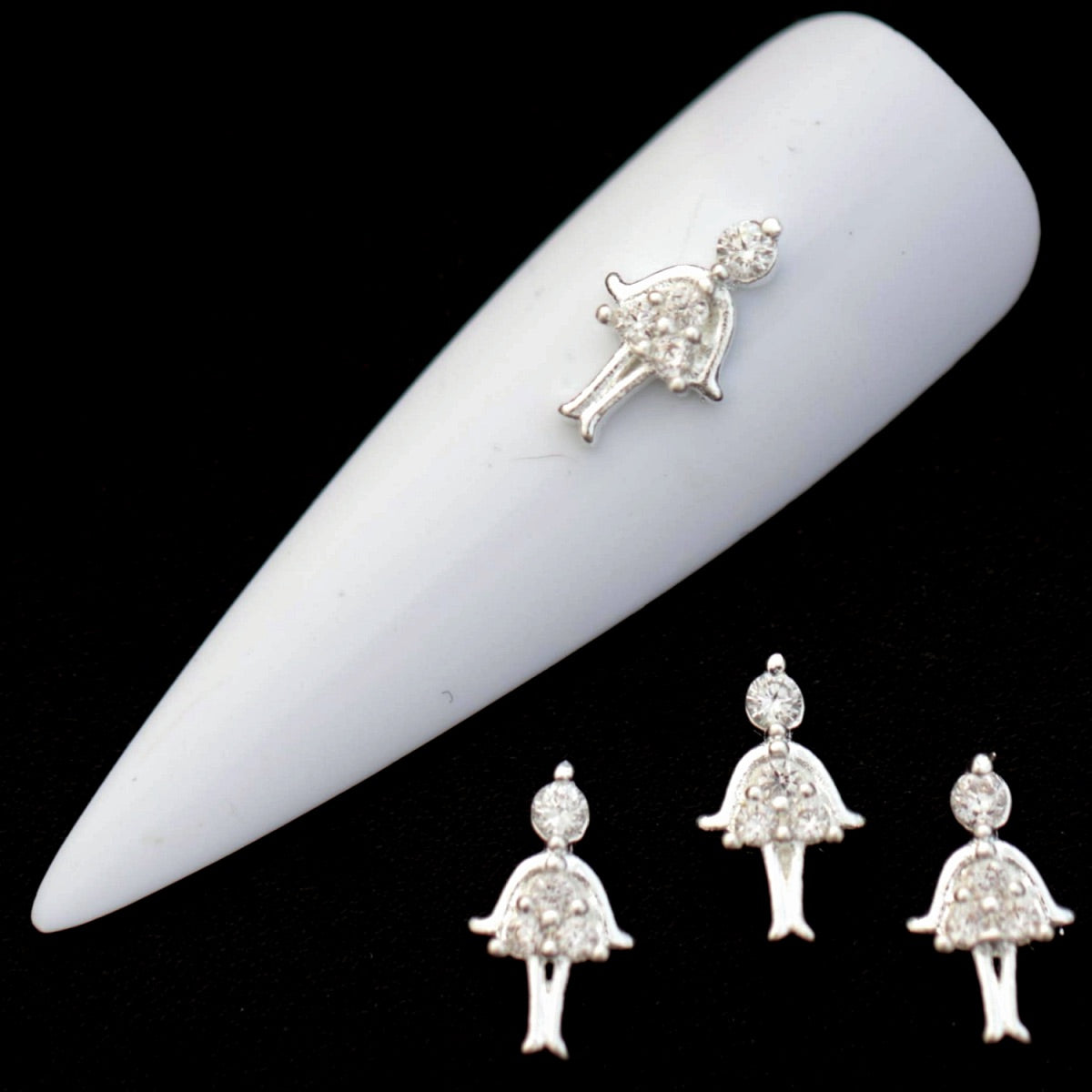 Silver ballerina nail charms with crystal CZ head and pavé tutu on a white nail tip against a black background